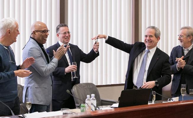 New DGA National Executive Director Russell Hollander accepts the office keys from former National Executive Director and current Senior Advisor Jay D. Roth as Secretary-Treasurer Michael Apted (l), President Paris Barclay and Board Member Steven Spielberg (r) applaud the transition.