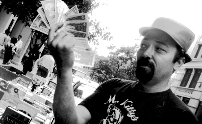 Street Bookseller Pete Whitney Holds a Wad of Cash, in 'BookWars'